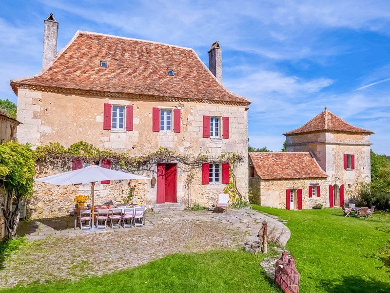 SHOKO standing before a honey-stone Périgord country house in the Dordogne