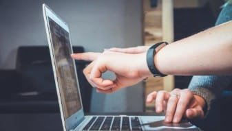 مستشار وعميل يراجعان عقارات على حاسوب محمول
